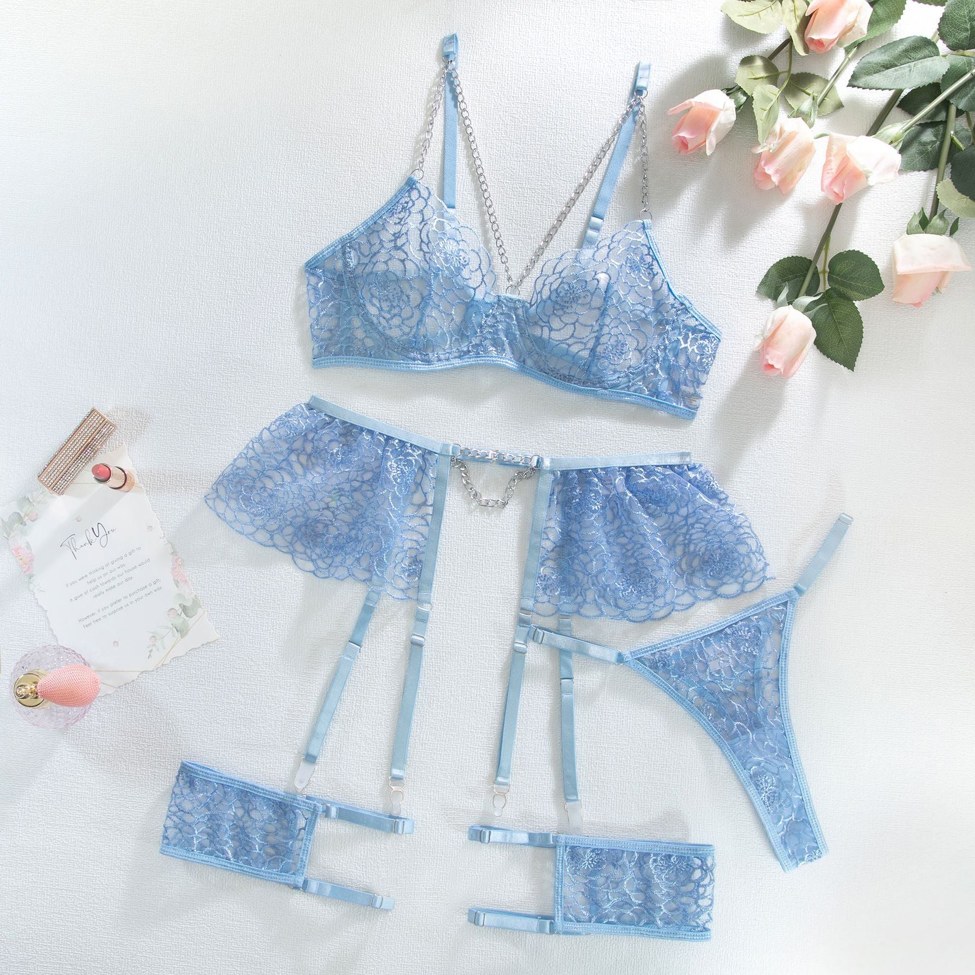Ensemble de lingerie sexy quatre pièces avec chaîne en métal, string et tanga.